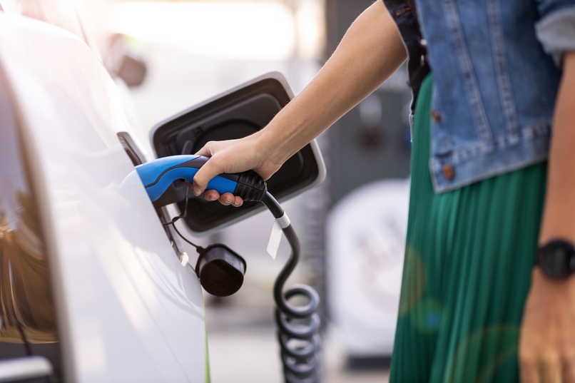 mujer cargando Vehículo Eléctrico