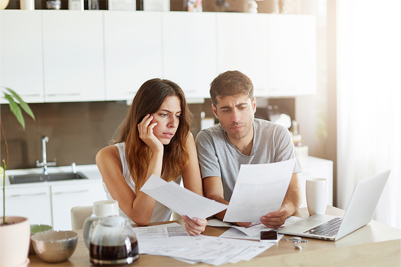 Pareja leyendo documentos para comparar precios de la luz