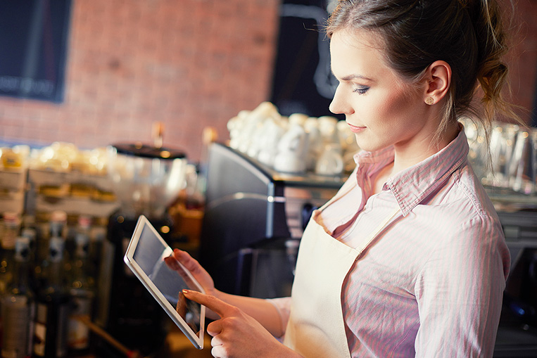 propietaria de cafetería consultando el alta de la luz en una tablet