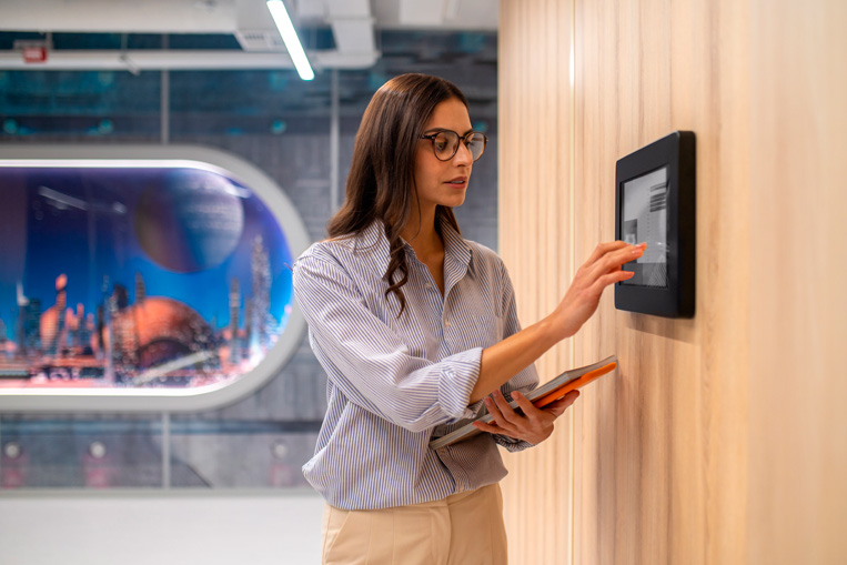 mujer en oficina activando en una pantalla el aire acondicionado