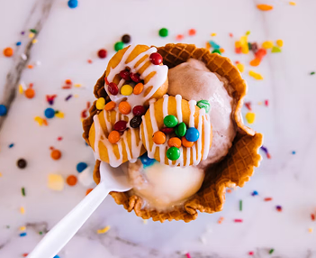 detalle de un helado de cucurucho con toppings de colores por encima