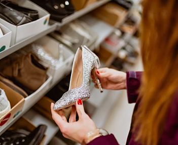 una mujer observa un zapato de tac&oacute;n en una tienda
