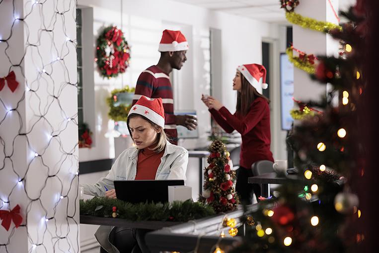 Trabajadores en oficina decorada con luces de Navidad
