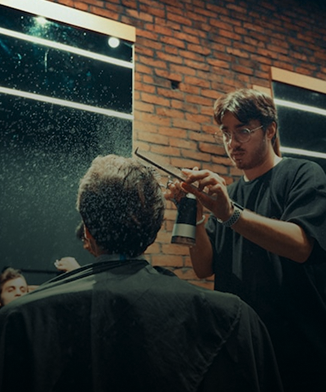 barbero peinando a un hombre adulto que est&aacute; de espaldas