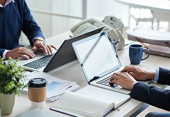 dos empleados trabajando con el portátil en una oficina