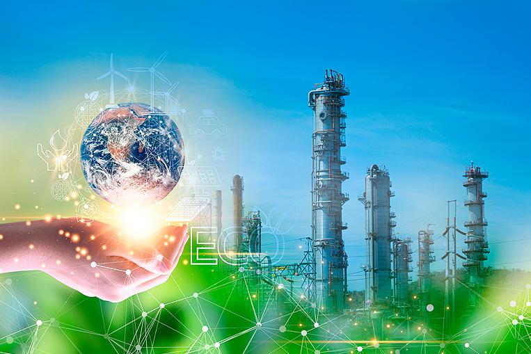 mano sosteniendo el planeta tierra con una fábrica al fondo