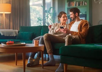 pareja sentada en el sofá mirando el móvil